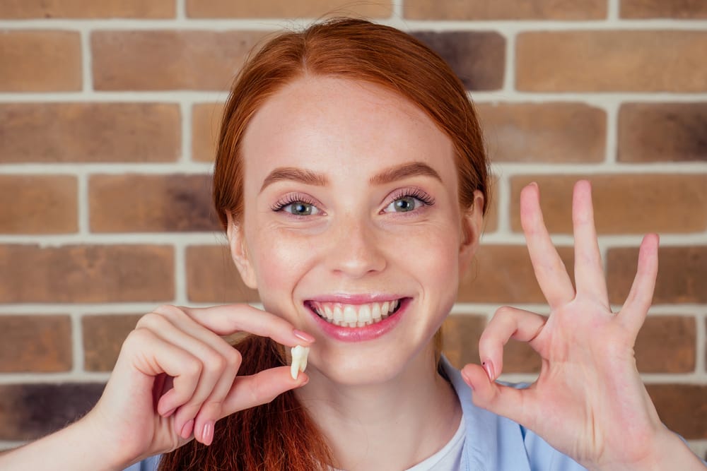 woman holding extracted tooth